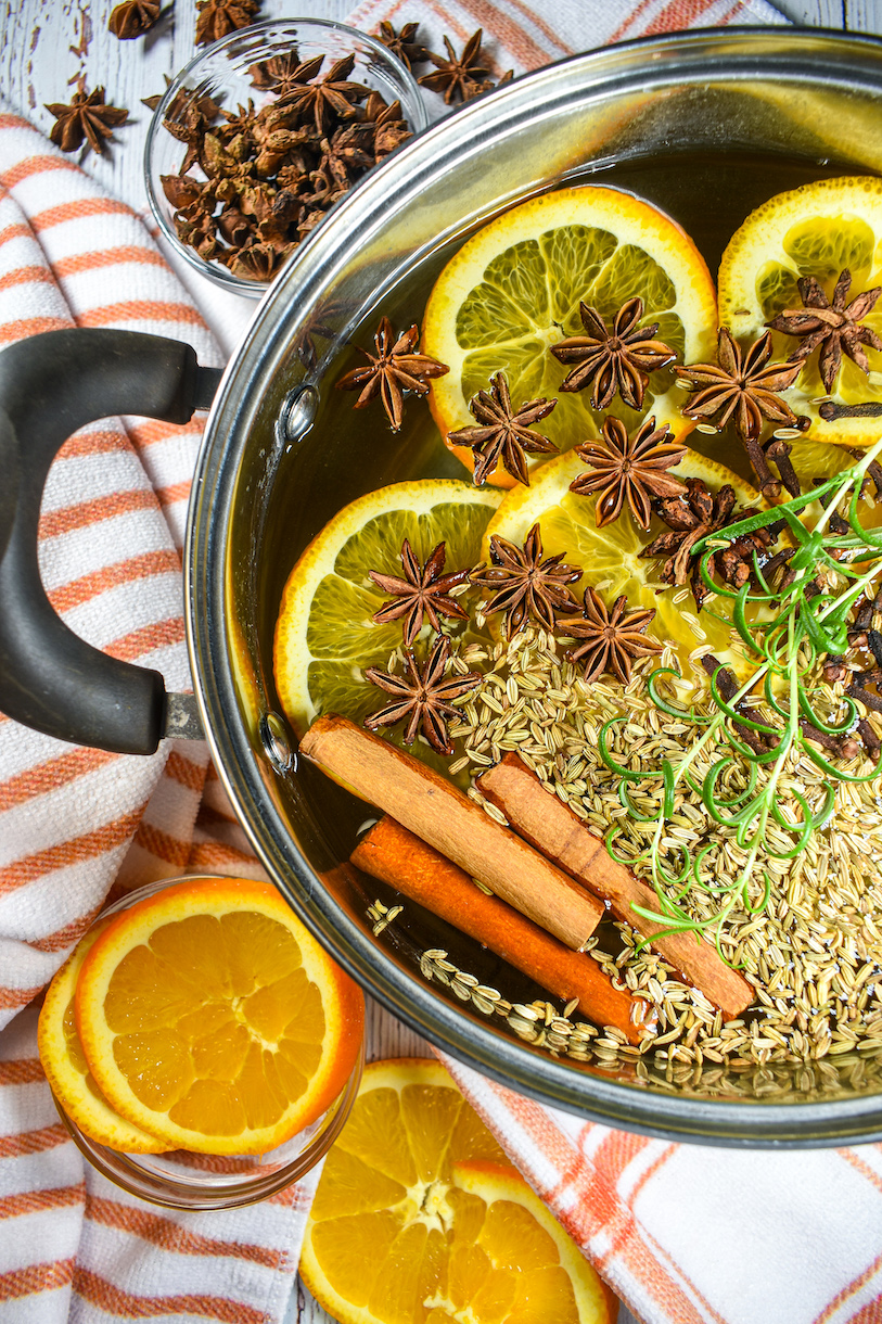 anise and orange simmer pot with a striped towel and bowl of oranges