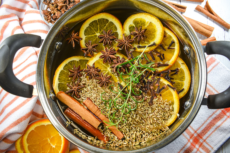 An orange simmer pot surrounded by striped towels