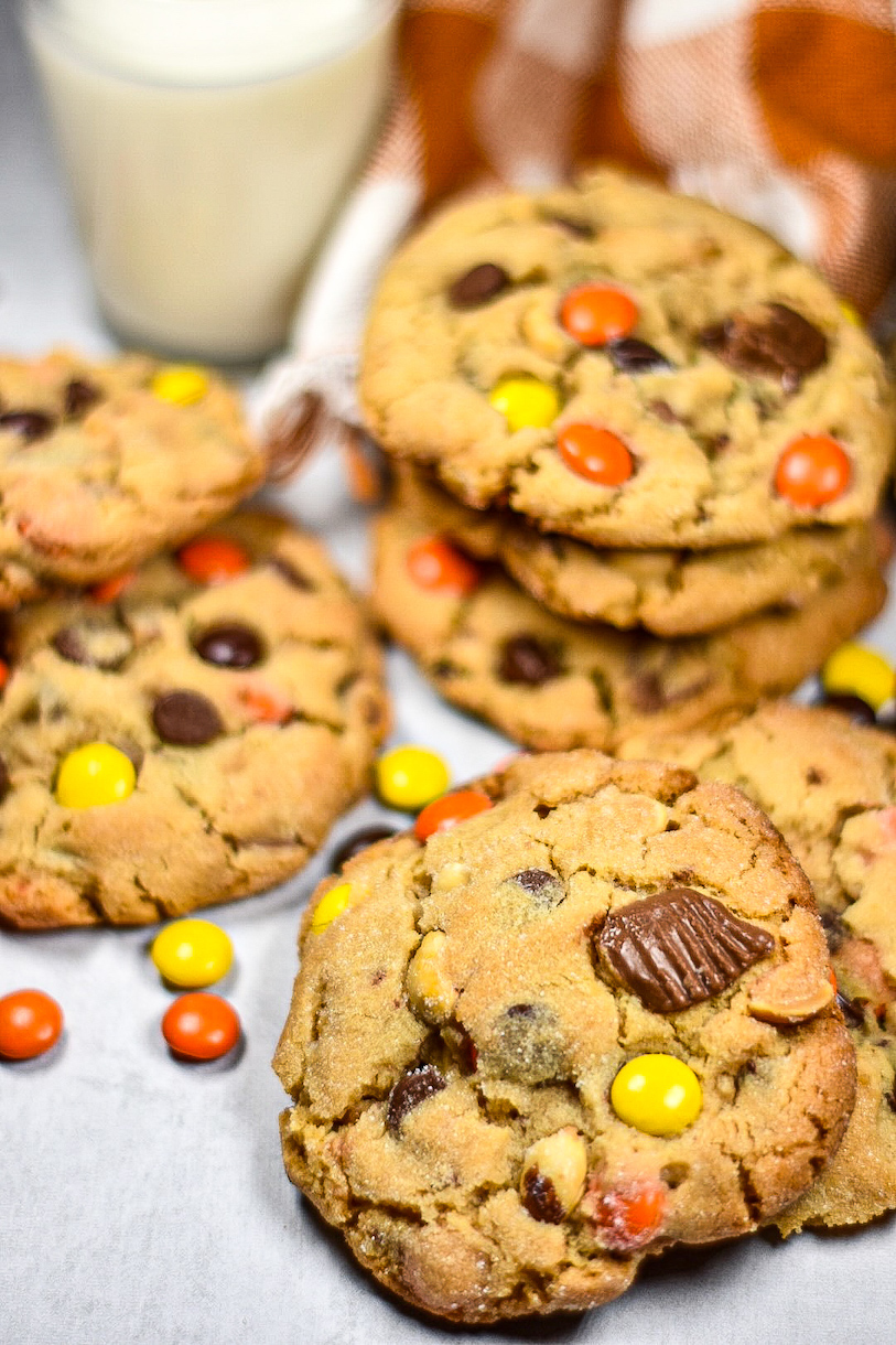 Peanut butter cookies on a white surface with Reese's Pieces