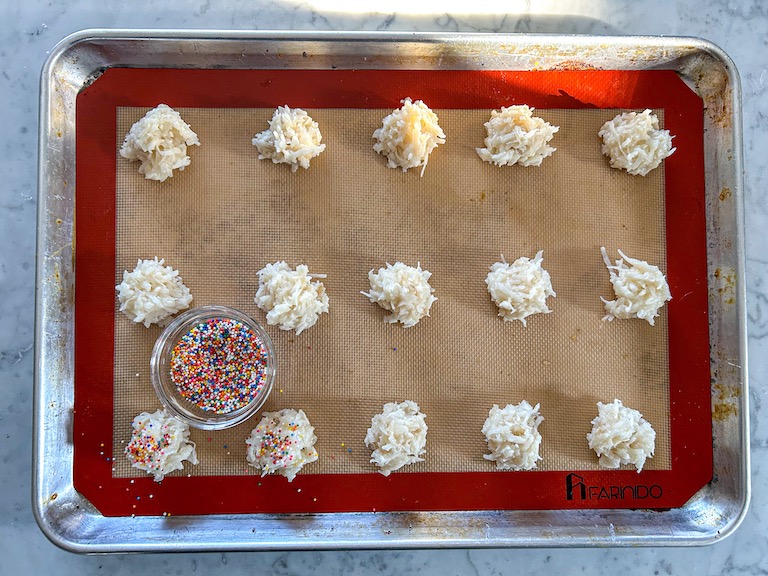 Adding rainbow sprinkles to coconut macaroons