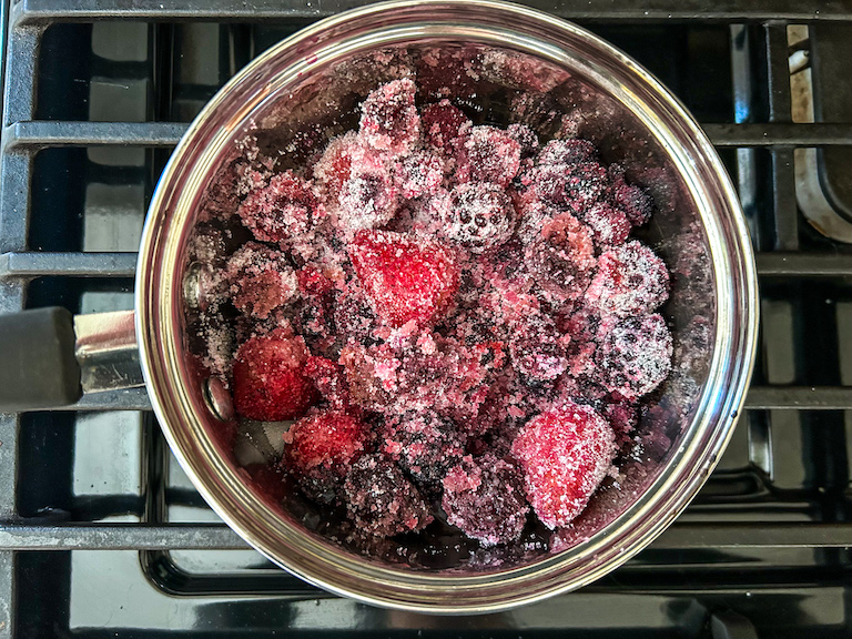 berries and sugar in a saucepan