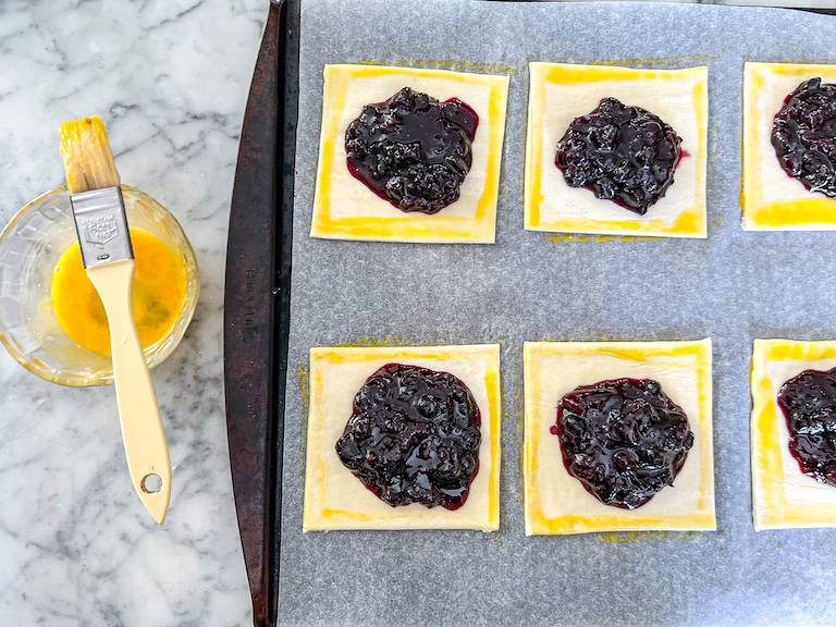 squares of puff pastry with jam and egg washed edges