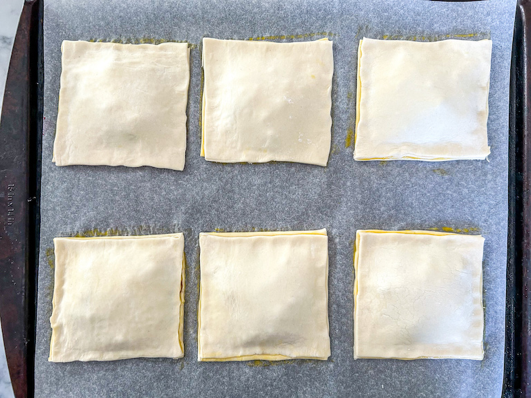 Squares of puff pastry on a tray