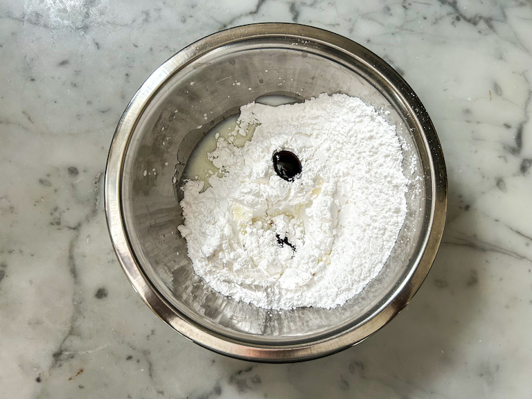 Confectioner's sugar in a bowl with food coloring and milk