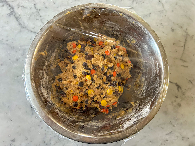 Cookie dough in bowl covered with plastic wrap