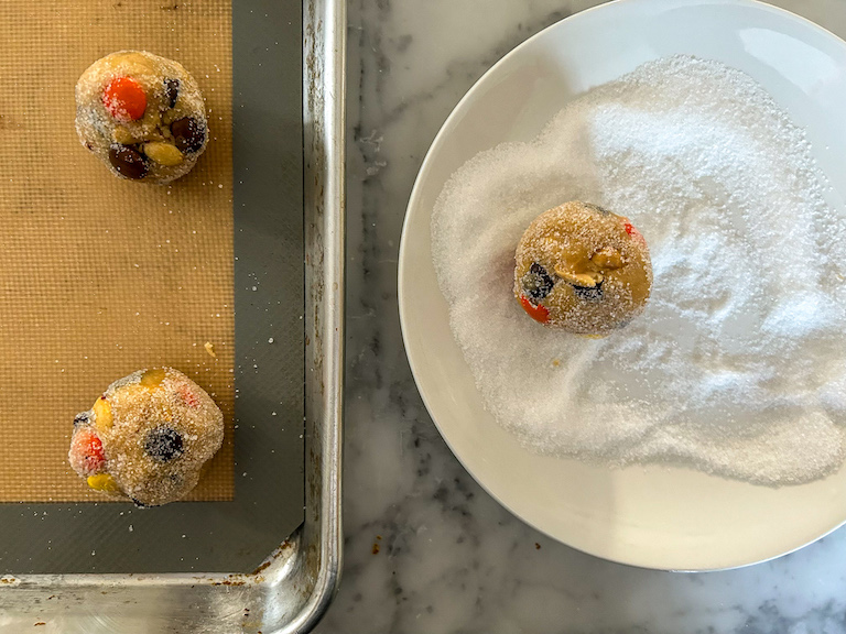 Rolling balls of peanut butter cup cookie dough in sugar