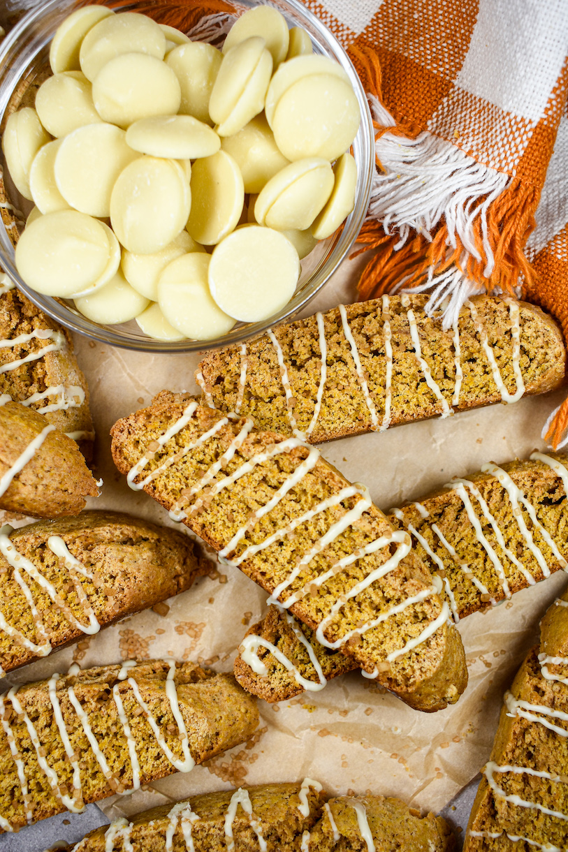 Dish of white chocolate, orange checkered towel, and homemade pumpkin spice biscotti cookies