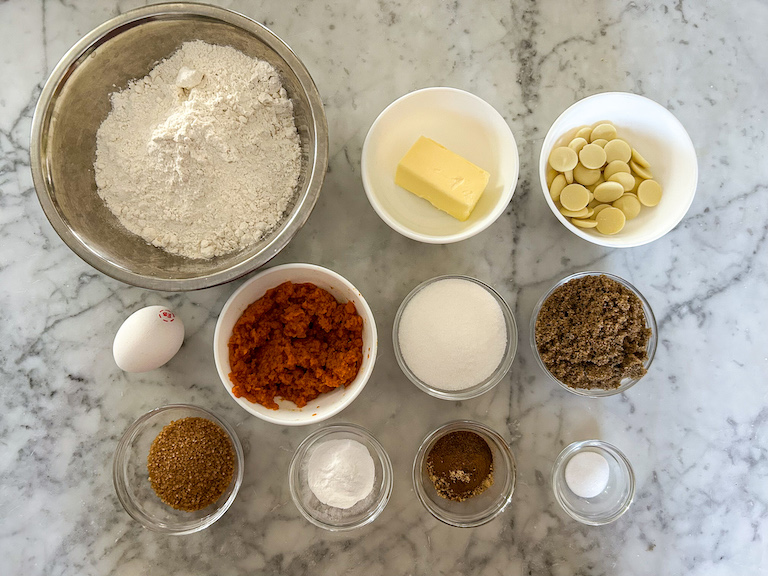 Pumpkin biscotti ingredients arranged on a marble surface