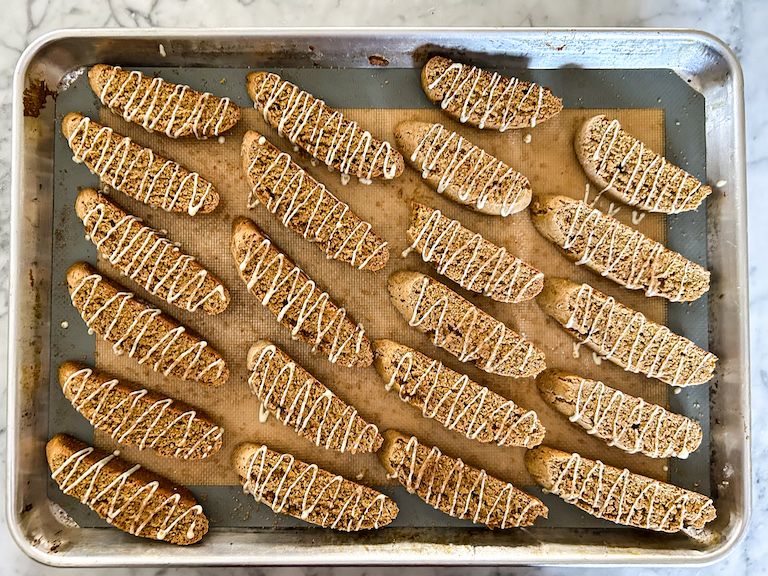 A tray of pumpkin biscotti drizzled with white chocolate