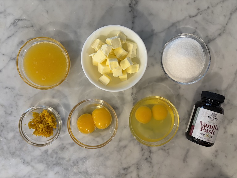 Orange curd ingredients on a marble surface
