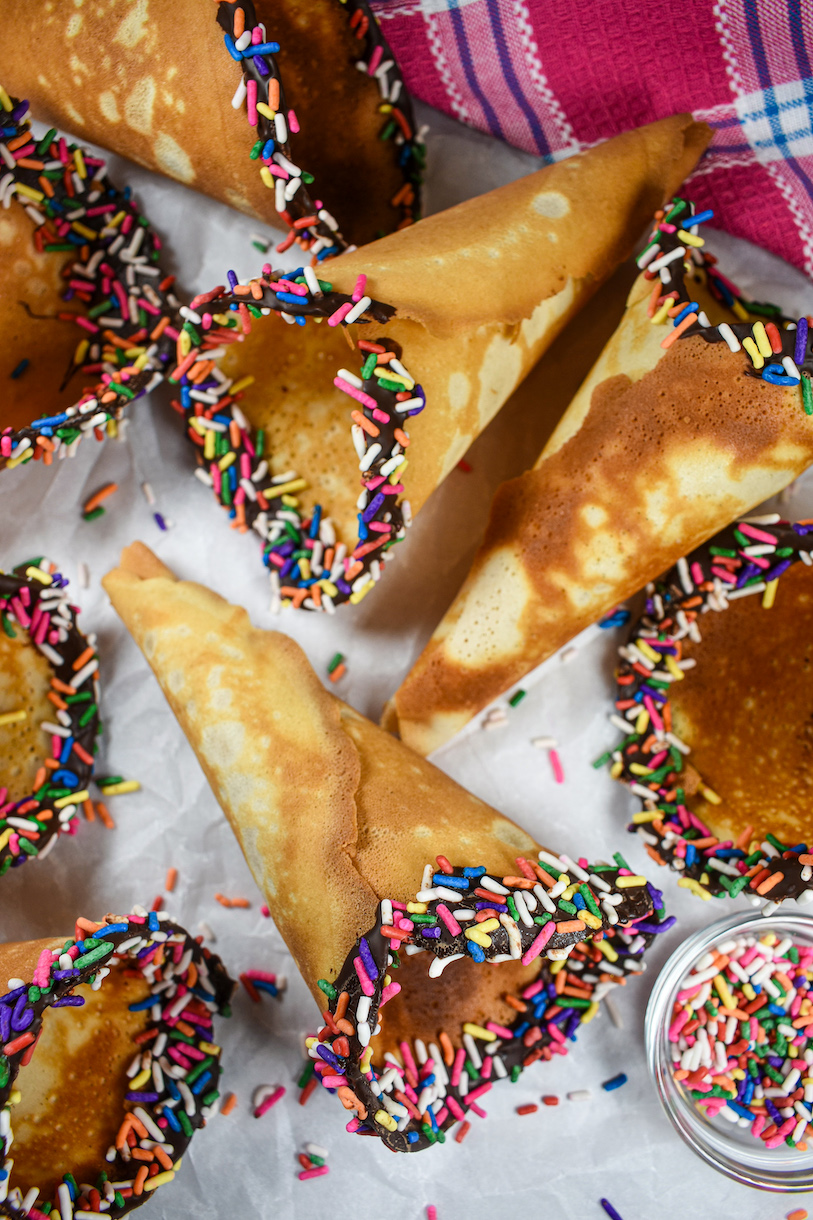 Homemade ice cream cones with rainbow sprinkles and chocolate