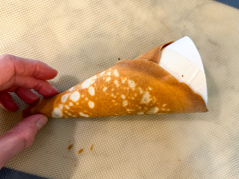 hand shaping the bottom of an ice cream cone