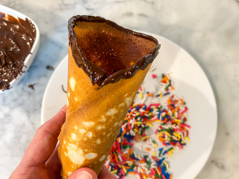 Hand holding a chocolate dipped ice cream cone
