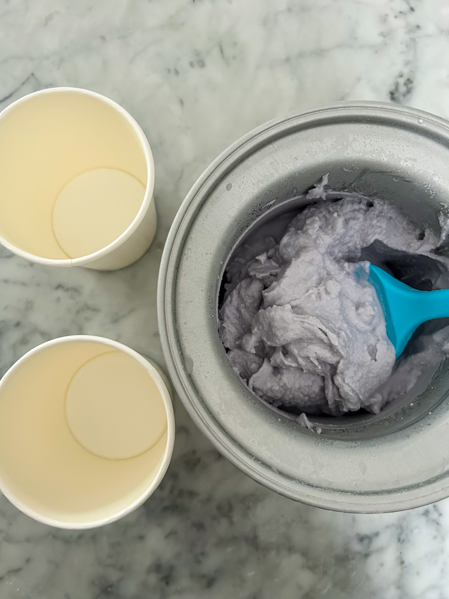 Two pint containers and an ice cream maker with lavender ice cream