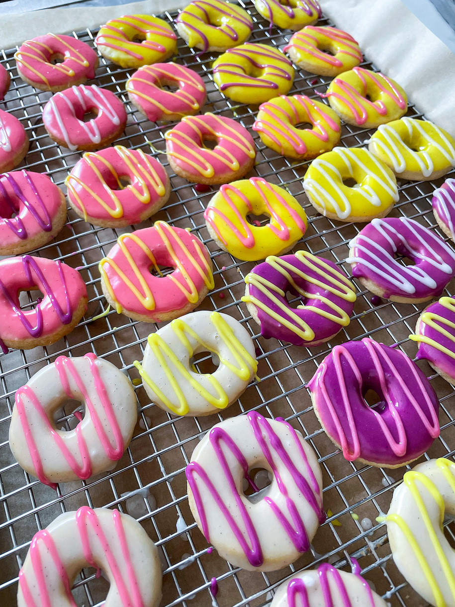 Iced party ring biscuits on a wire rack