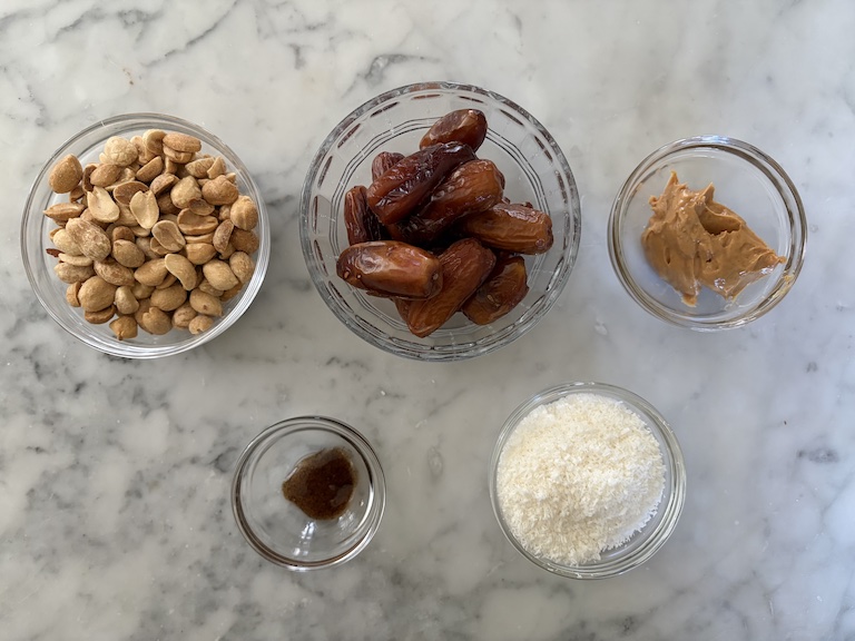 Coconut date ball recipe ingredients on a marble surface