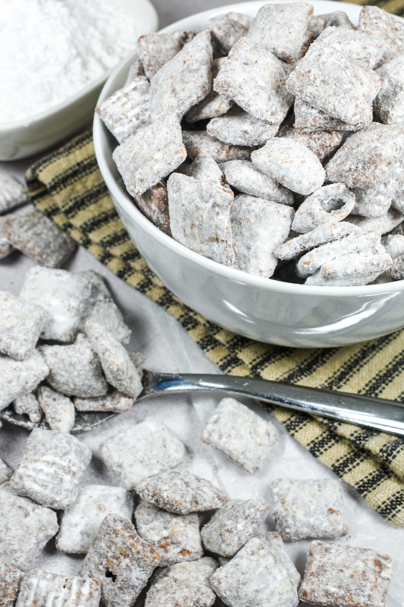 Bowl of puppy chow with a striped towel and a spoon
