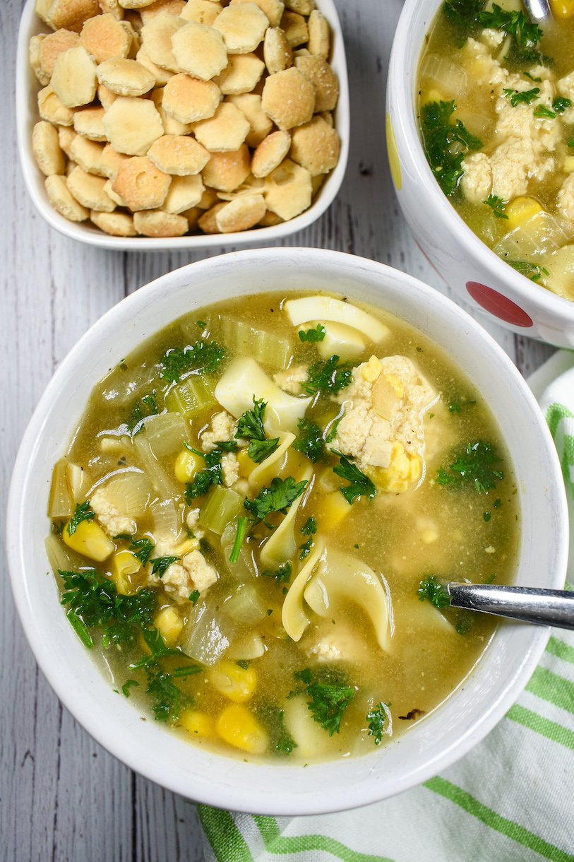 A bowl of vegetarian chicken corn soup with a spoon
