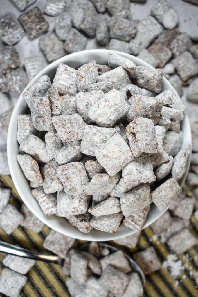 dish of puppy chow arranged on a striped tea towel