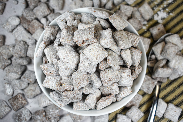 A bowl of puppy chow with a spoon