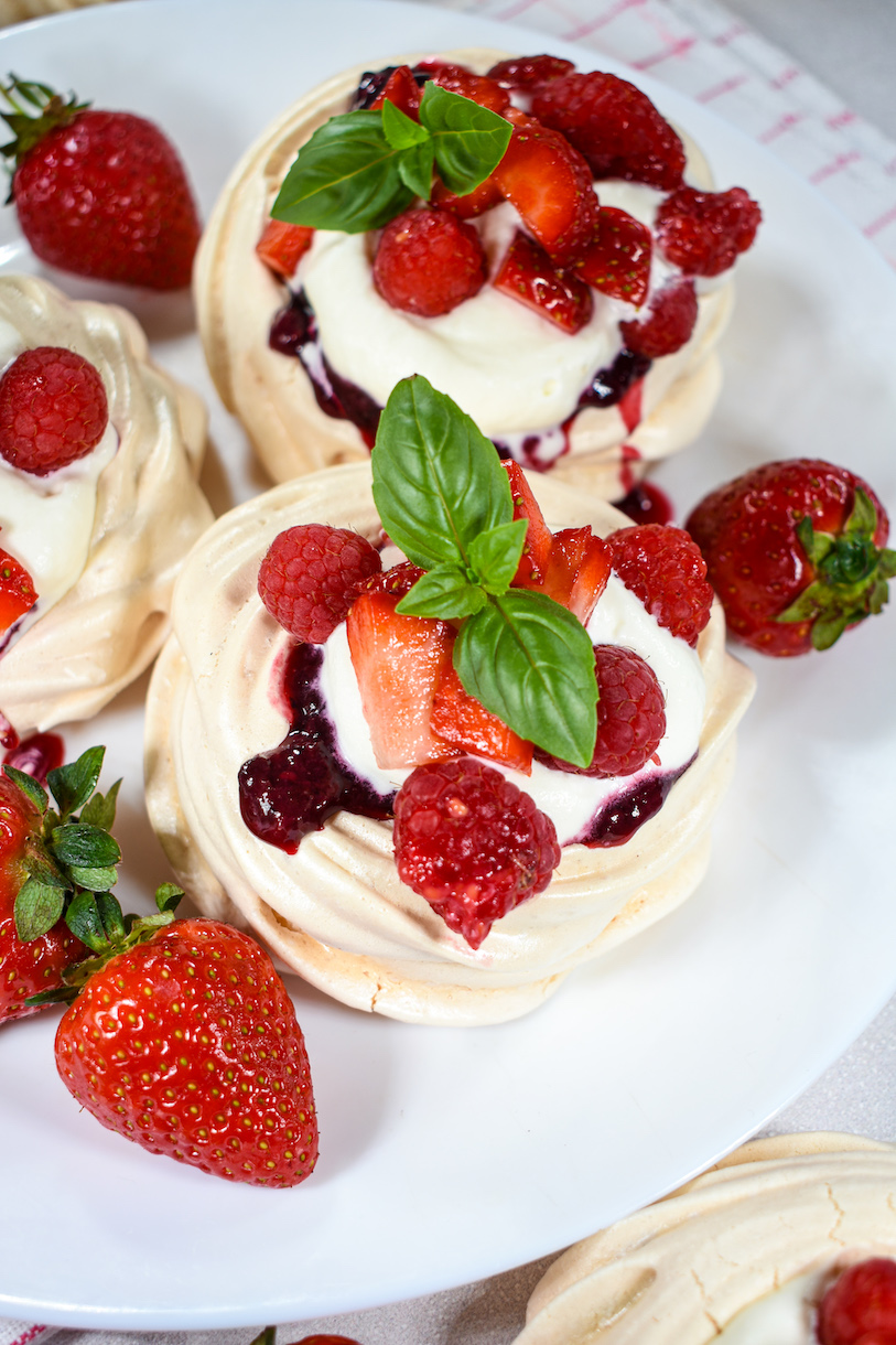 Mini pavlovas decorated with berries and cream
