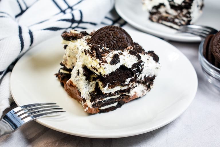 A square of Oreo icebox cake on a white plate with a fork