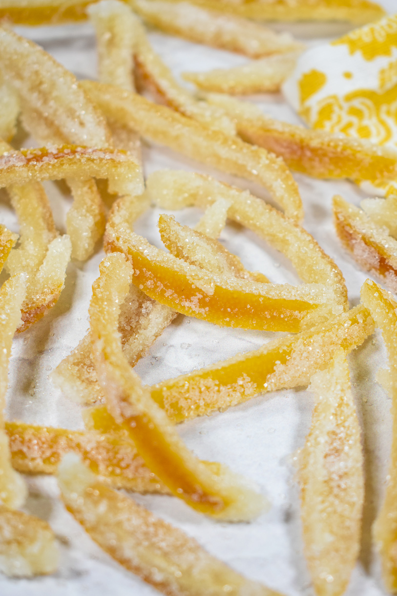 Candied lemon peel slices on a white surface