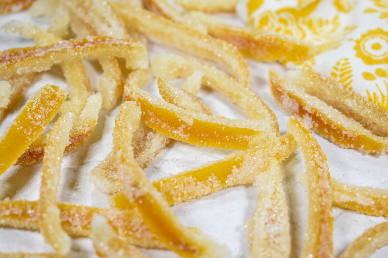 Candied lemon peels arranged on a white surface