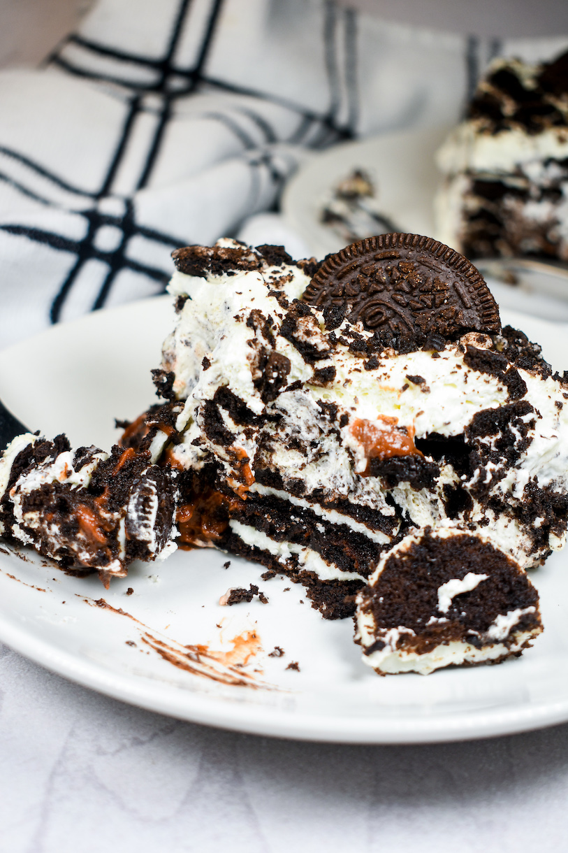 A slice of half eaten Oreo cake on a plate