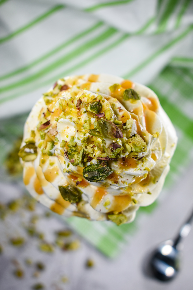 Looking down at a pistachio milkshake with whipped cream and chopped pistachio nuts on top