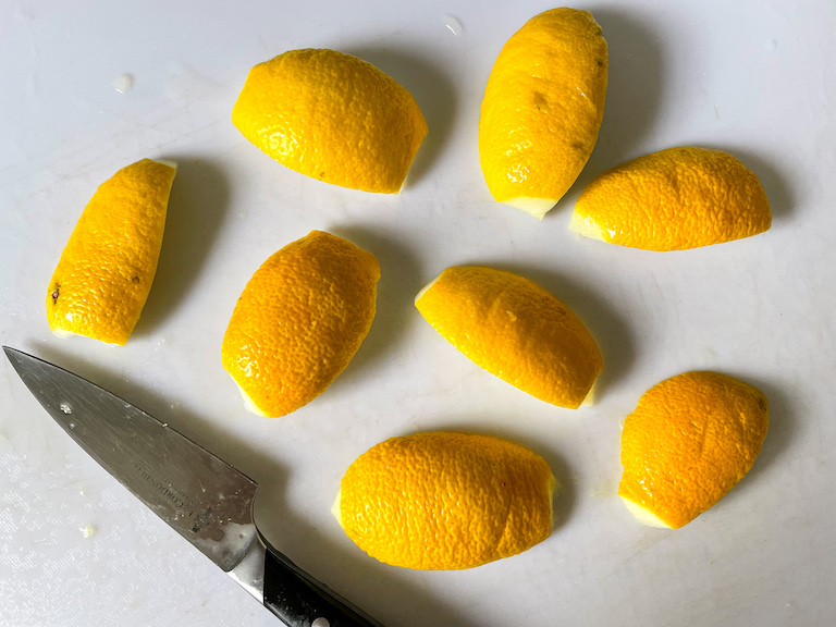 Lemon peels on a chopping board with a knife