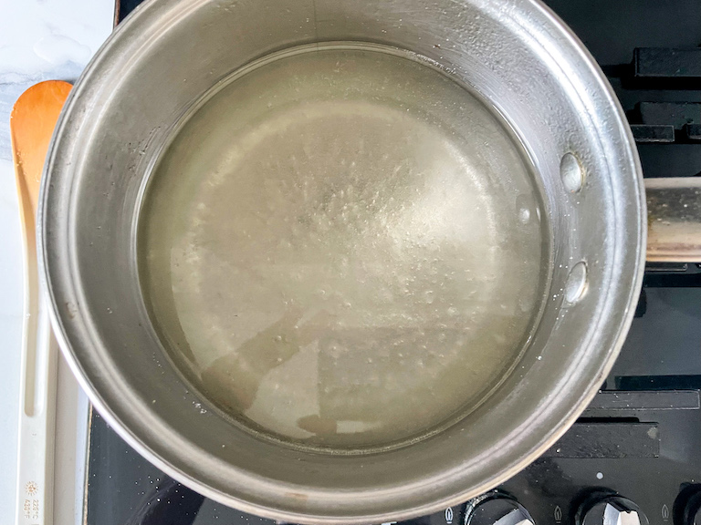 A saucepan of sugar water on a stovetop