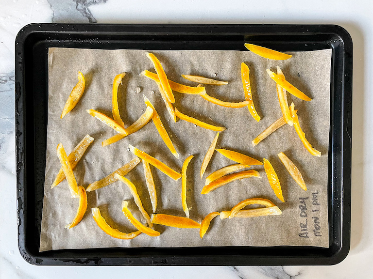 Sugar soaked lemon peel strips on a tray