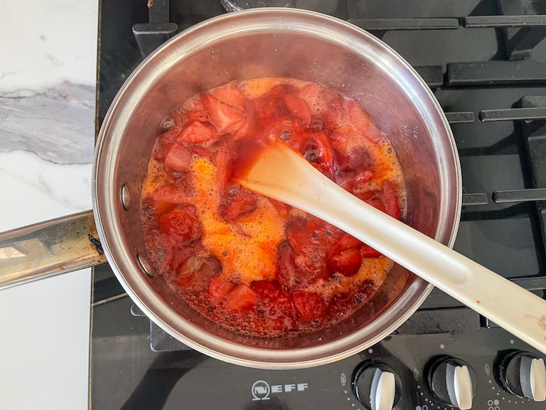 Strawberry compote cooking in a pan on the stovetop