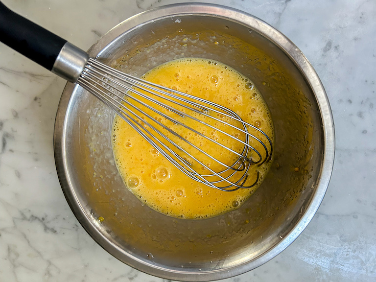 Whisking a bowl of curd with a wire whisk