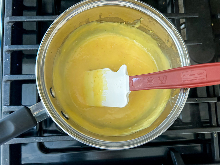 Grapefruit curd cooking in a saucepan on the stovetop