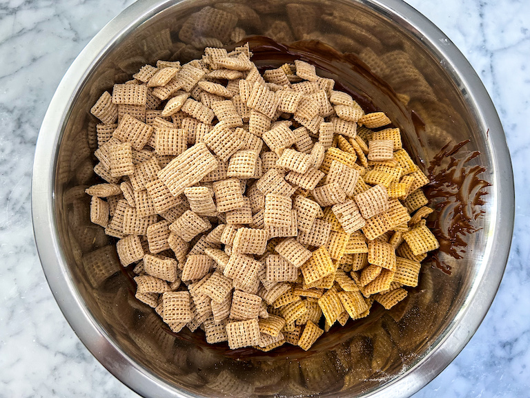 Stirring chex mix into melted chocolate
