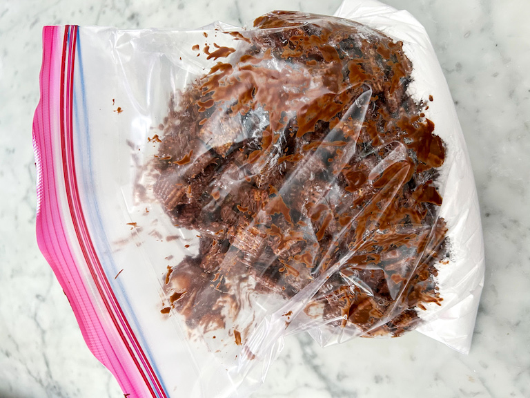 Chocolate coated cereal in a plastic bag with confectioner's sugar