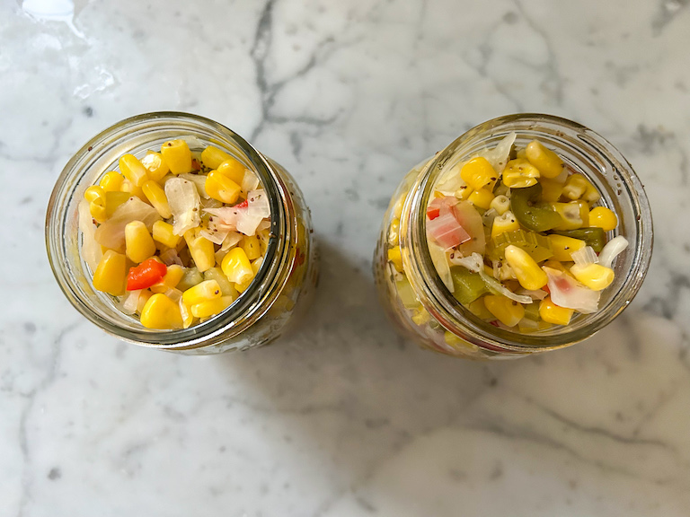 Two jars of homemade corn relish, without lids