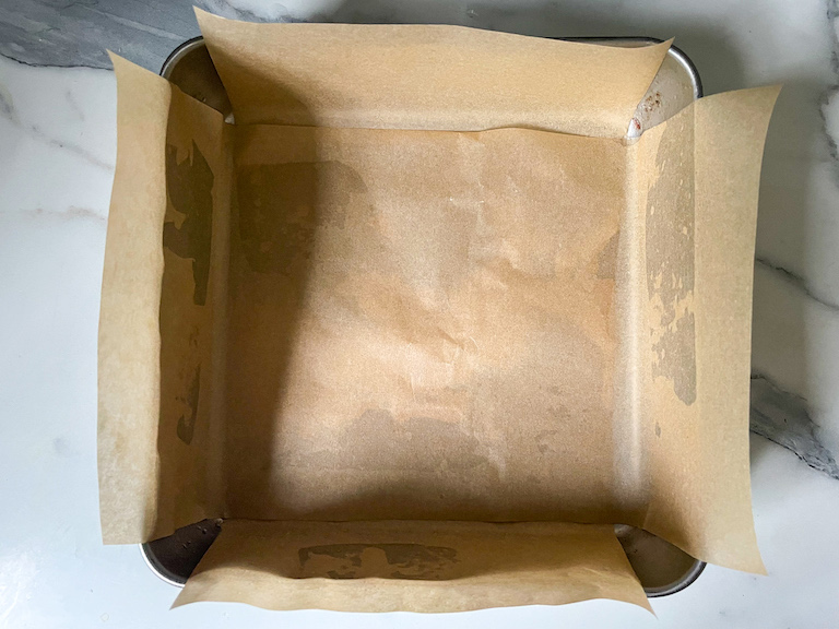 A square tin lined with brown parchment