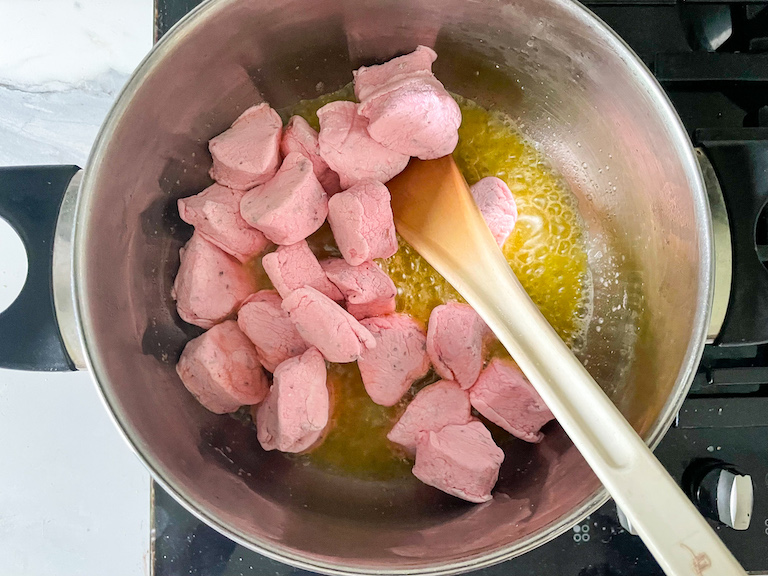 Pink heart shaped rose marshmallows in a pan of melted butter