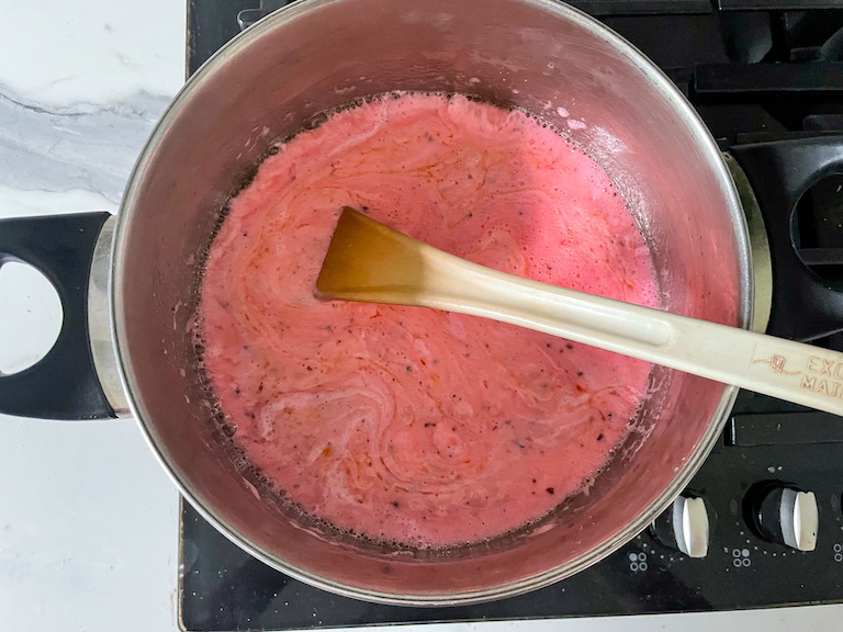 Melted pink marshmallow mixture in a pan on the stovetop