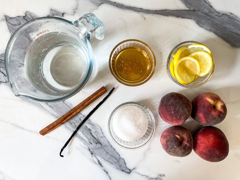 Vanilla poached peach recipe ingredients on a marble surface
