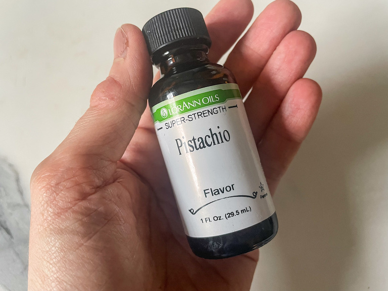 hand holding a bottle of pistachio flavoring