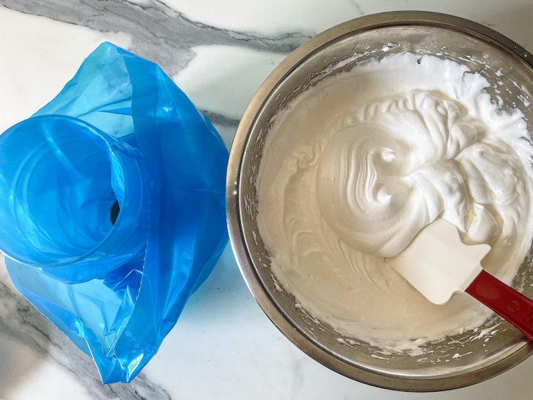 Bowl of meringue, spatula, and piping bag