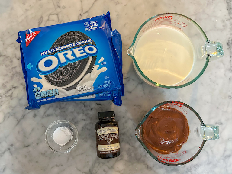 Ingredients for making an oreo icebox cake arranged on a marble surface
