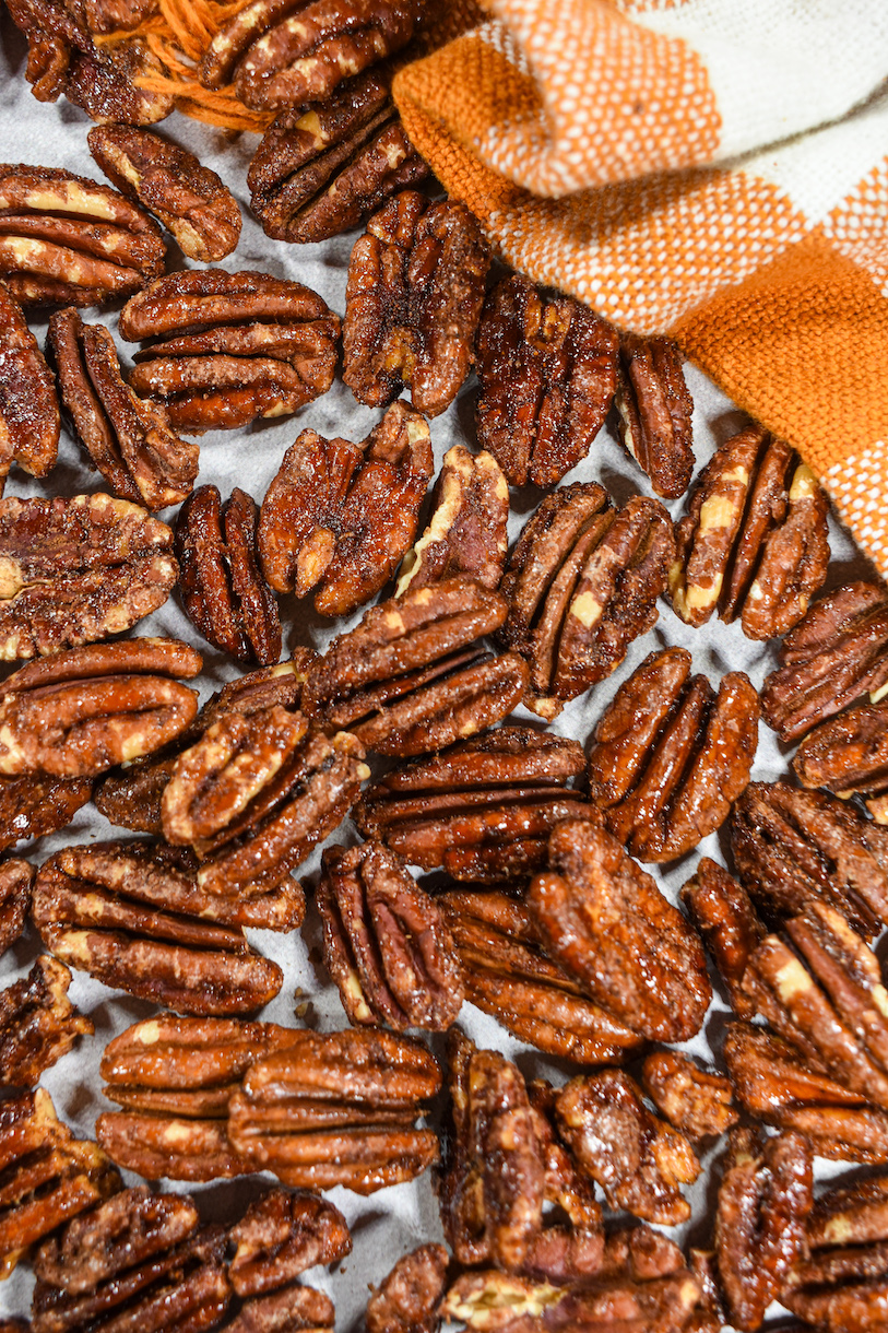 Maple pecans on a white surface with an orange towel