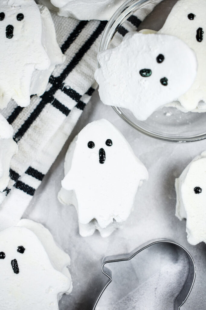 marshmallow ghosts on a white surface with a plaid tea towel