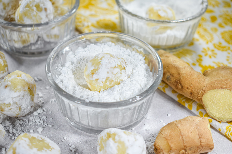 A bowl of powdered sugar with a ginger truffle