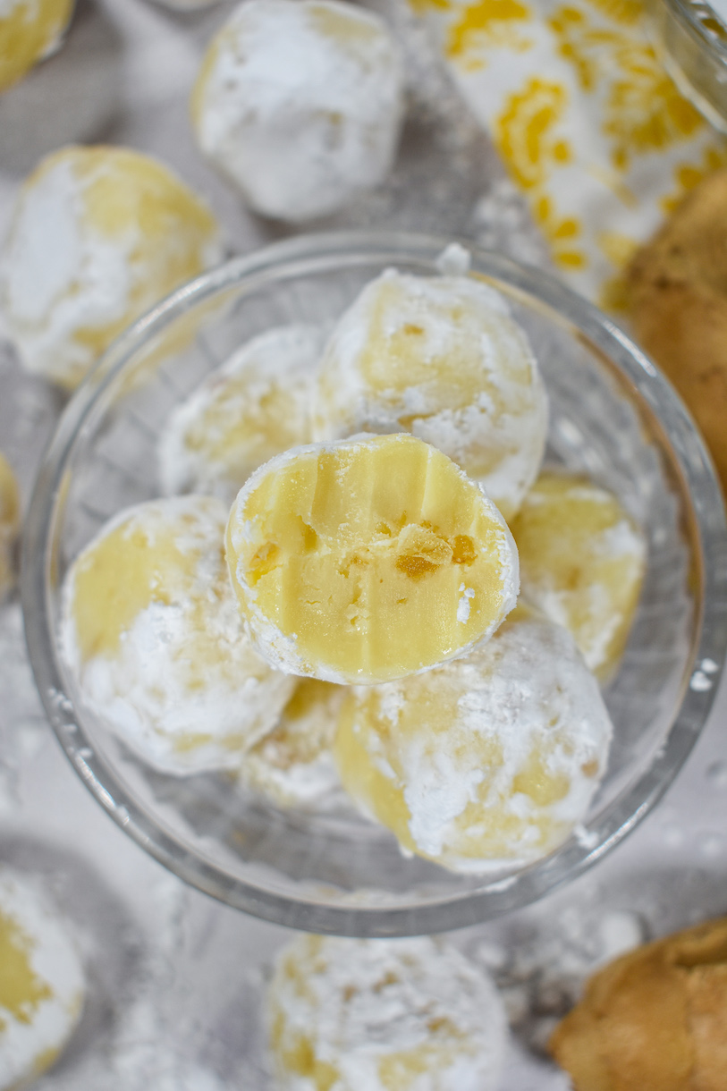 Bowl of white chocolate ginger truffles with a half-eaten truffle on top